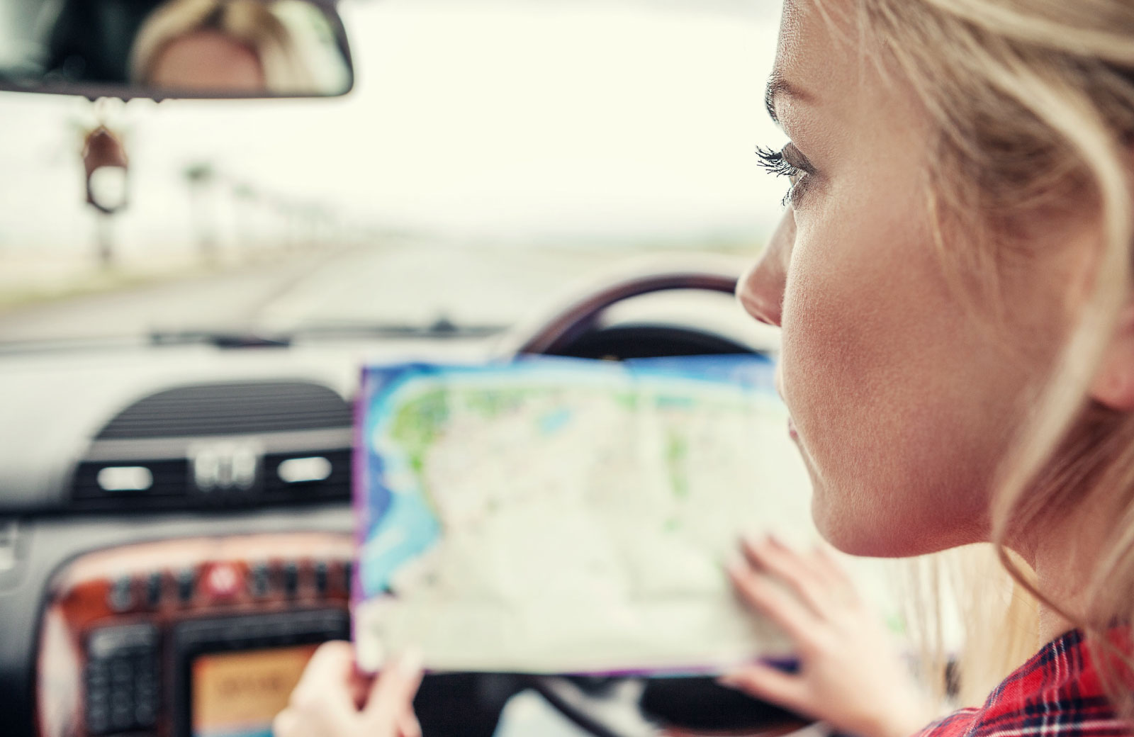 woman looking at a map while on the road