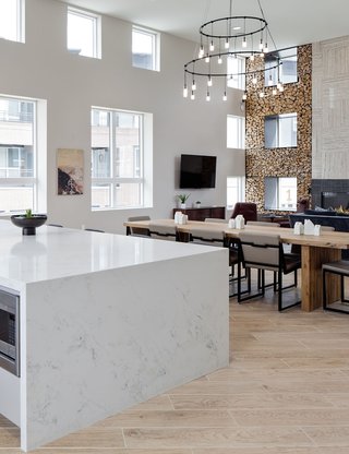 The white marbled island in the clubhouse kitchen, with a large dining table in view