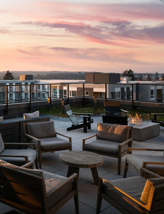 close up of roof top terrace seating and tables at dusk at Hyde Square Apts